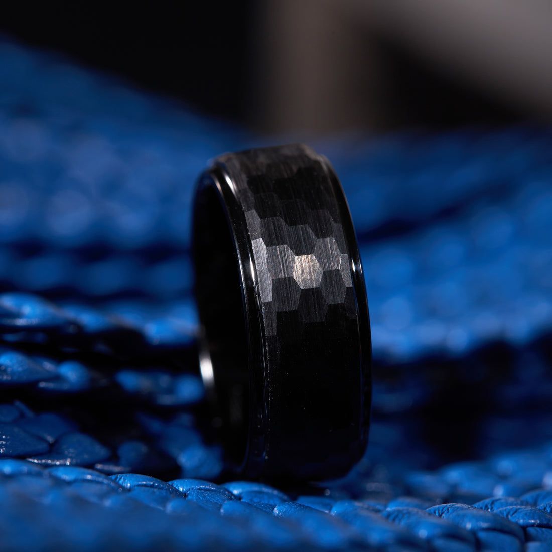 Close-up of an 8mm black tungsten carbide men's ring, showcasing custom engraving detail.