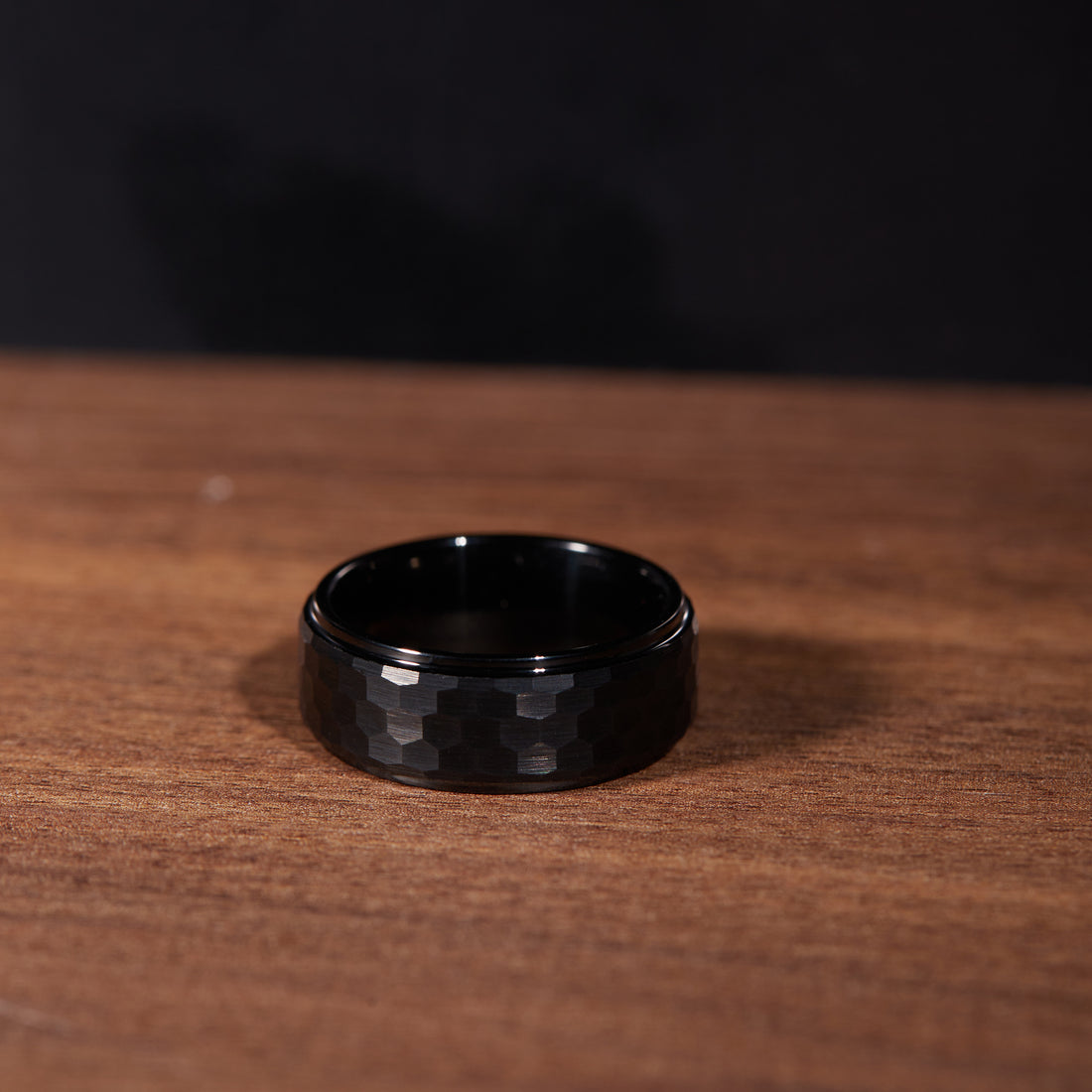 Close-up of an 8mm black tungsten carbide men's ring, showcasing custom engraving detail.