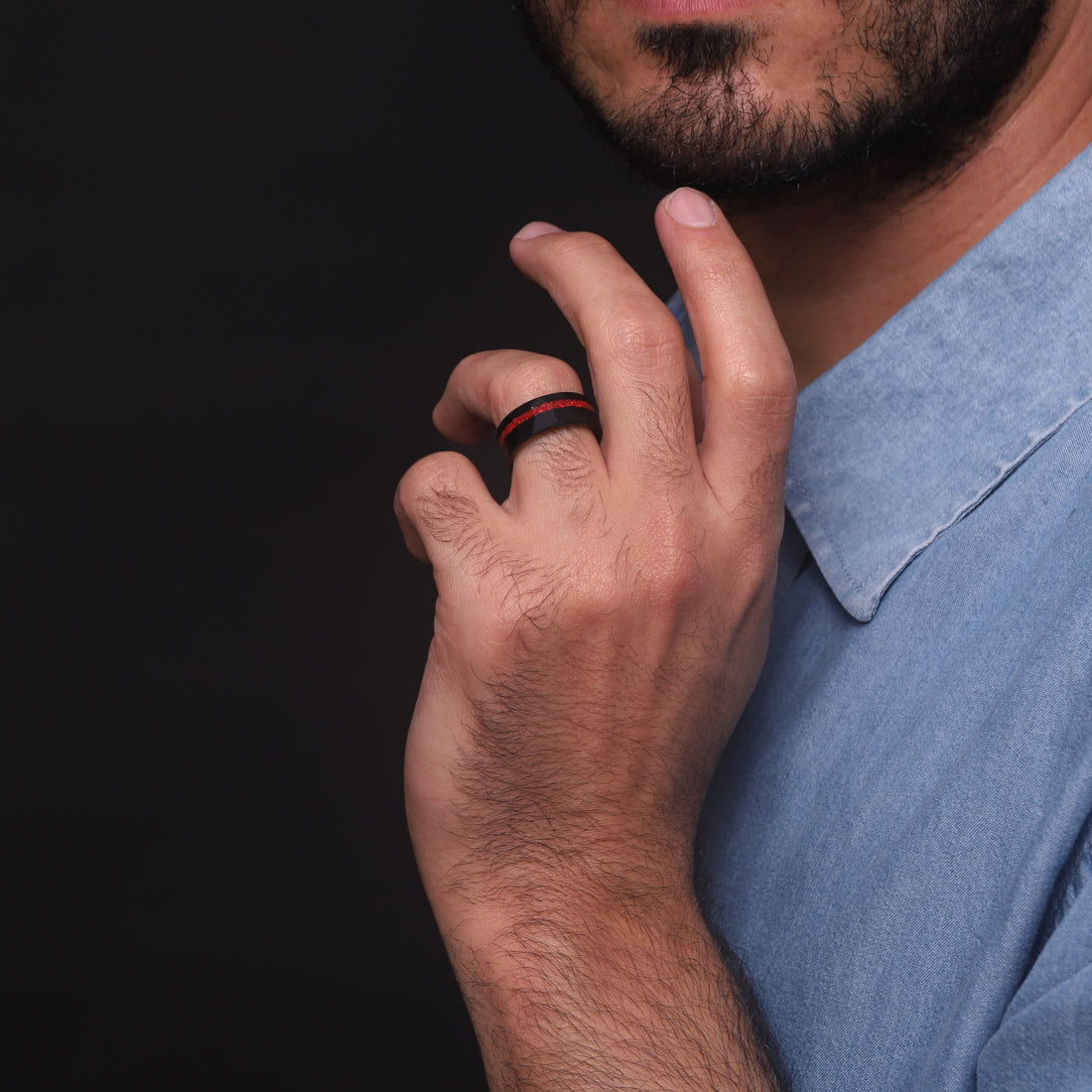 Masculine black tungsten ring for men, featuring a vibrant red opal in a finely hammered setting