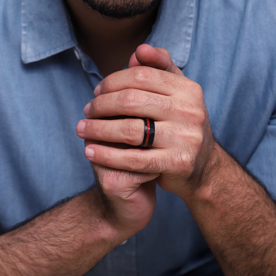 A striking combination of red opal and black tungsten in a men's ring, with a distinctive hammered effect for added texture