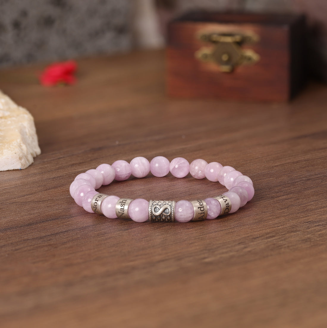 Personalized pink quartz bracelet with an Infinity charm, symbolizing eternal love.