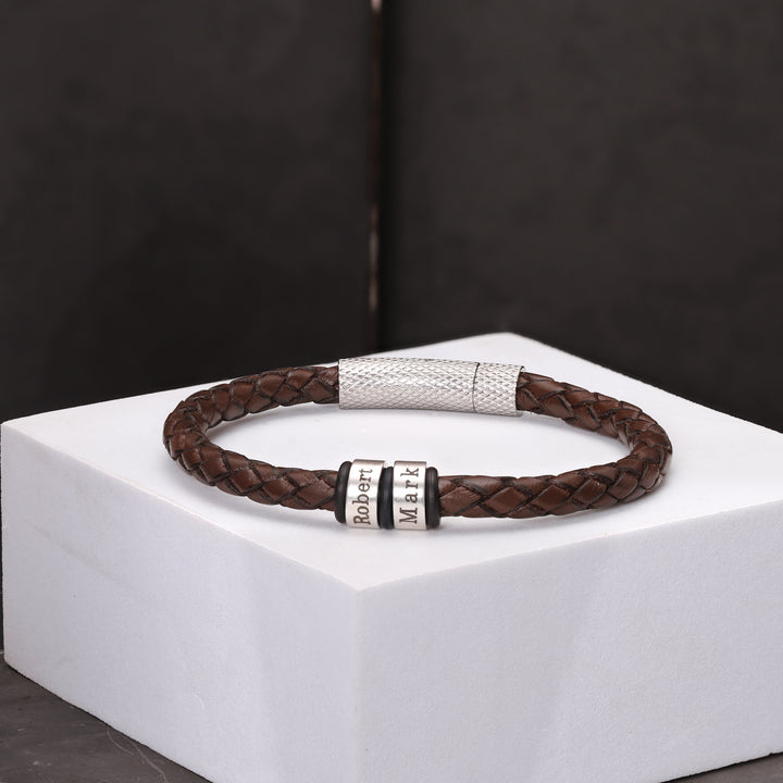 A brown leather bracelet with the option for custom name engraving, showcasing a rich, natural tone and classic craftsmanship