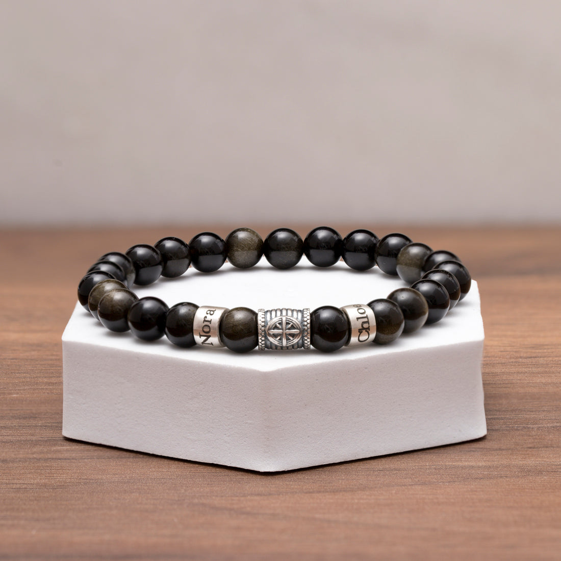 Black obsidian bead bracelet with engraved names and a silver compass charm, ideal for celebrating life's journey and cherished relationships