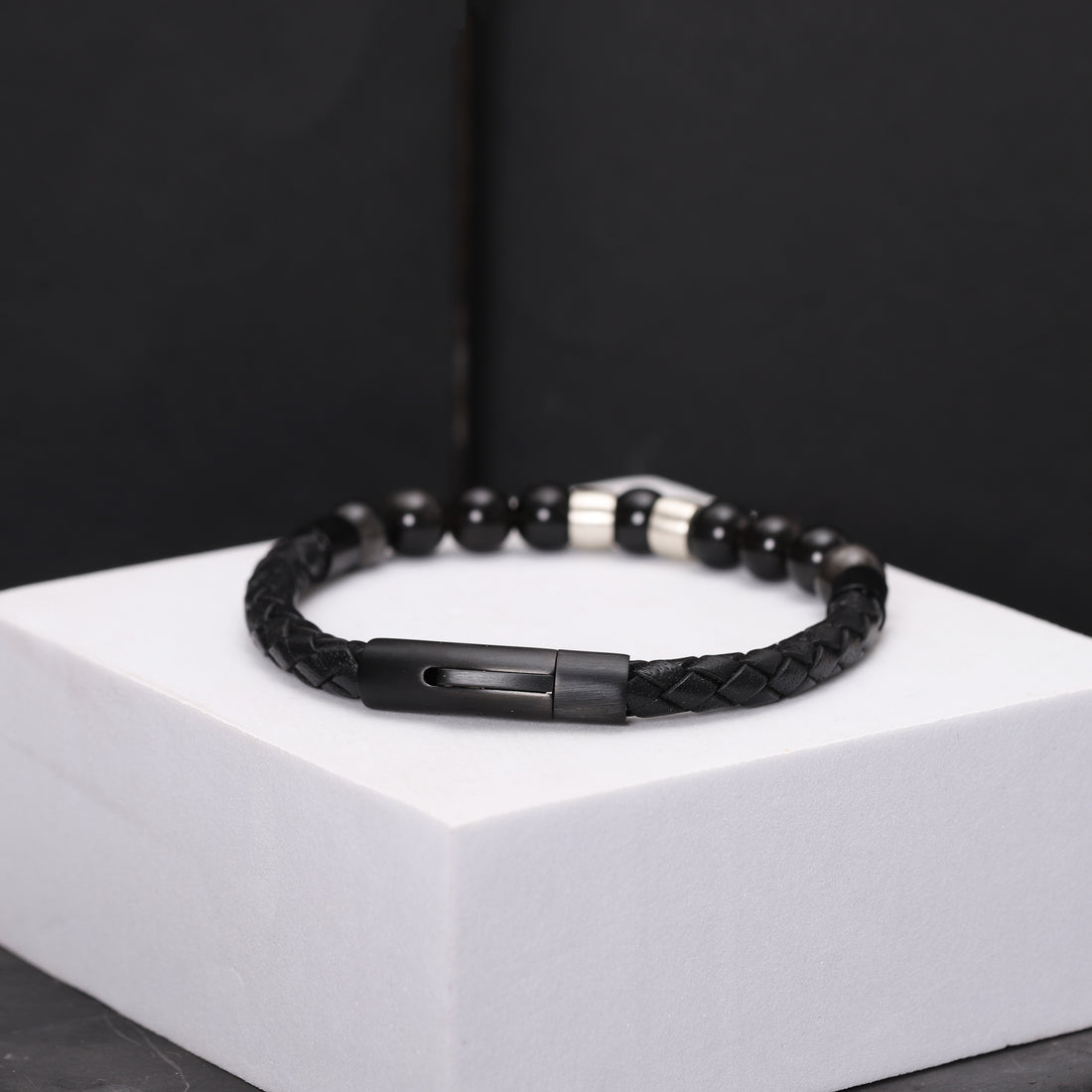 Men's bracelet featuring black obsidian beads and personalized sterling silver charms on a leather band