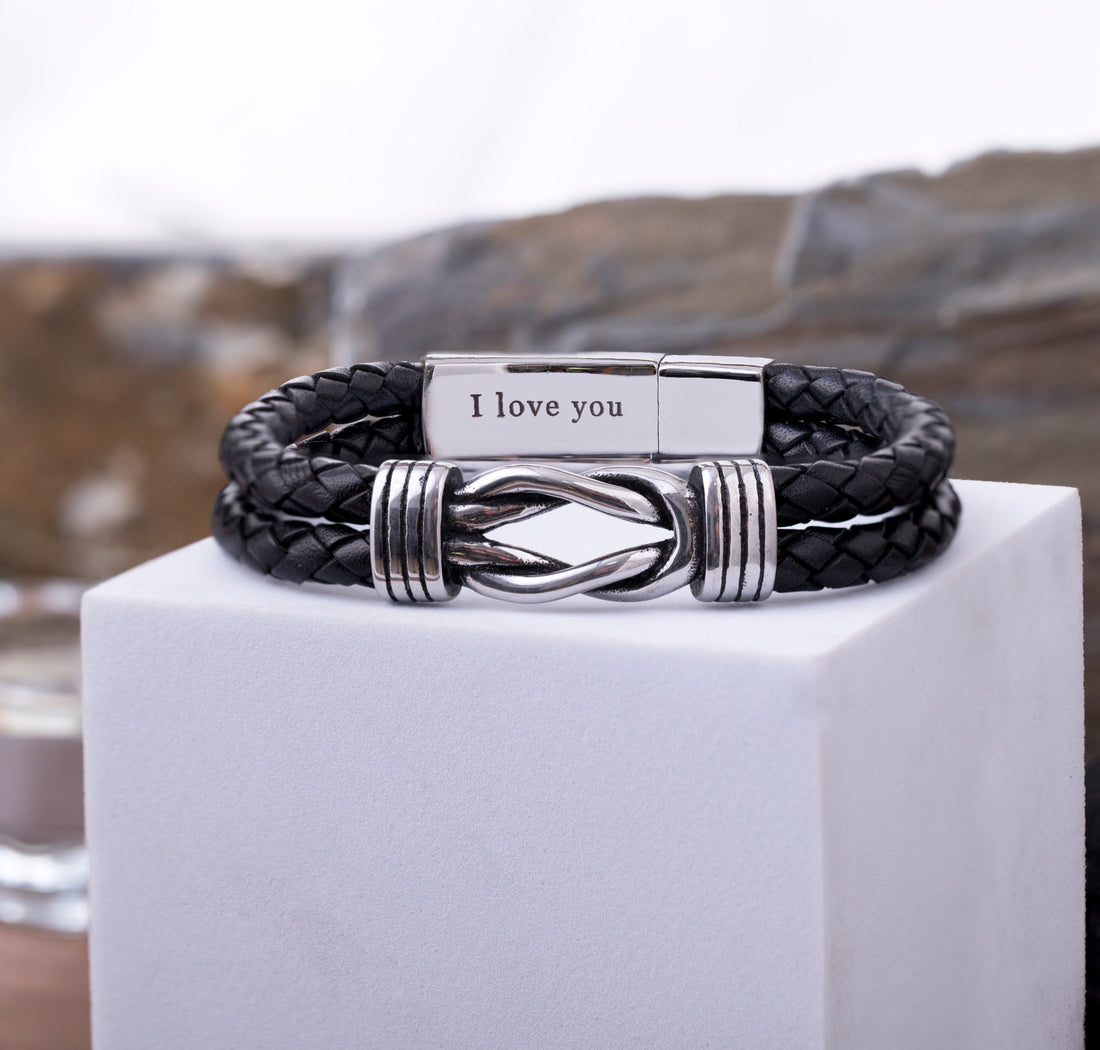 Close-up of a leather bracelet with an infinity charm, highlighting the detailed custom engraving inside the secure clasp